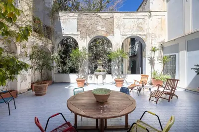 a patio with a table and chairs and a fountain at Dietro San Domenico Apartment in Palermo