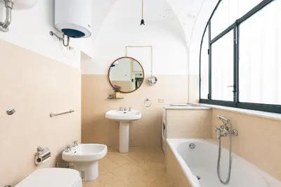 a bathroom with a sink and a toilet and a bath tub at Dietro San Domenico Apartment in Palermo