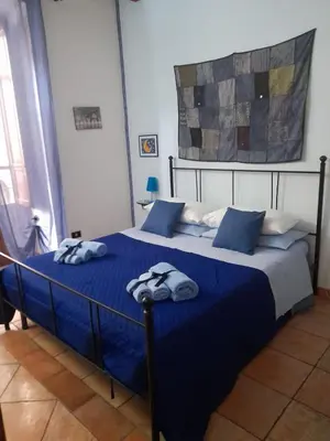 a bedroom with a blue bed with towels on it at Home Casa Professa 1 in Palermo