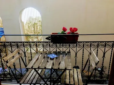 a balcony with a bench and a vase with roses at Home Casa Professa 1 in Palermo