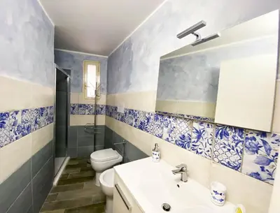 a blue and white bathroom with a toilet and a sink at Le case di Ninni - Monfenera in Palermo