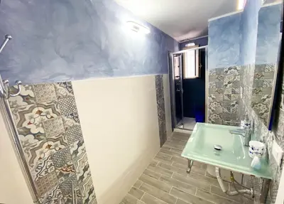 a bathroom with a green sink and a shower at Le case di Ninni - Monfenera in Palermo