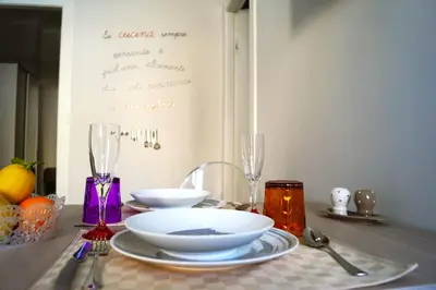 a table with plates and bowls and glasses on it at Le case di Ninni - Monfenera in Palermo