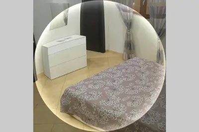 a room with a table and a round mirror at Isabella house in Casteldaccia
