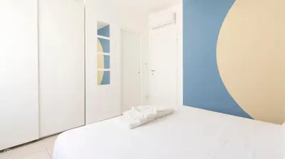 a bedroom with a white bed with a mirror at Visitsicilia Azzurra Mare in Alcamo Marina