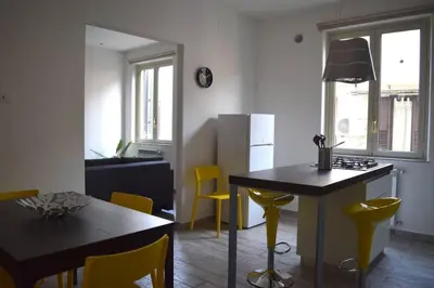 a kitchen and dining room with a table and yellow chairs at 29/4 Exclusive Suite tra Teatro Massimo e Porto in Palermo