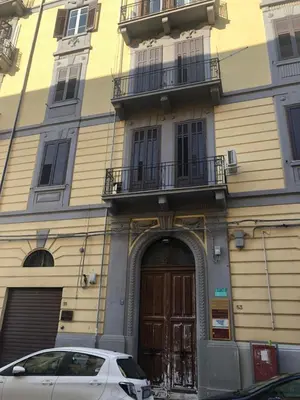 a white car parked in front of a building at BARRIQUE Guest House in Palermo