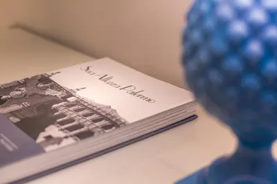 a book sitting on a table next to a blue vase at La Home42 Suite in Palermo