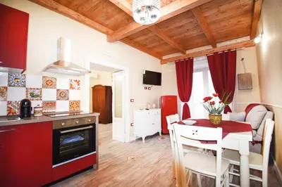 a kitchen and a living room with a table and chairs at Luxury Apartment Via Genova in Palermo