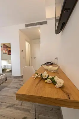 a wooden table with flowers on it in a room at Sundeck Hotel in San Vito lo Capo