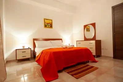 a bedroom with a bed with a red blanket at Casa vacanza da Marisa in Partinico
