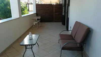 a porch with a chair and a table and a door at Dimora Di Campagna in Portella di Mare