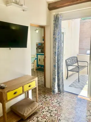 a living room with a television and a table at Casa Colore Attic in Castellammare del Golfo