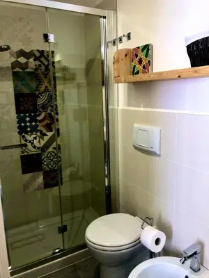 a bathroom with a shower and a toilet and a sink at Casa Colore Attic in Castellammare del Golfo