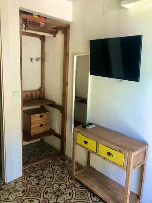 a room with a tv and a table and a mirror at Casa Colore Attic in Castellammare del Golfo