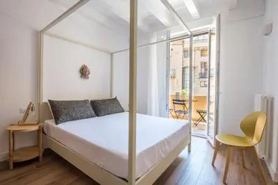 a white bedroom with a bed and a chair at Le Niche Holiday Homes by Wonderful Italy in Palermo