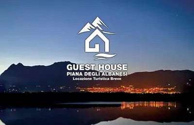 a sign for a guest house with a mountain at GUEST HOUSE PIANA DEGLI ALBANESI in Piana degli Albanesi