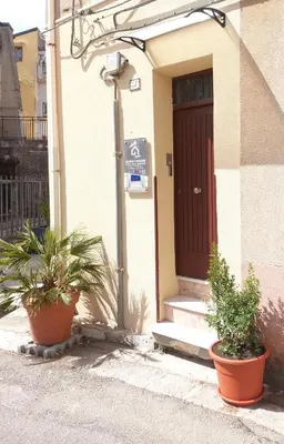 a house with two potted plants in front of a door at GUEST HOUSE PIANA DEGLI ALBANESI in Piana degli Albanesi