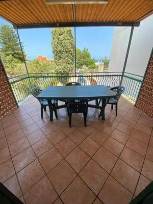a patio with a table and chairs on a balcony at Casa Vacanza in Trabia