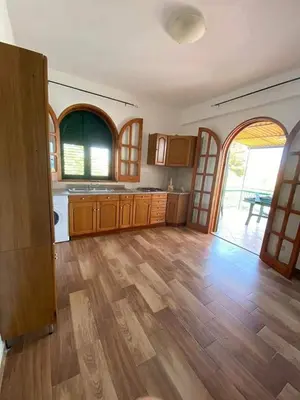 a large kitchen with wooden floors and an open door at Casa Vacanza in Trabia