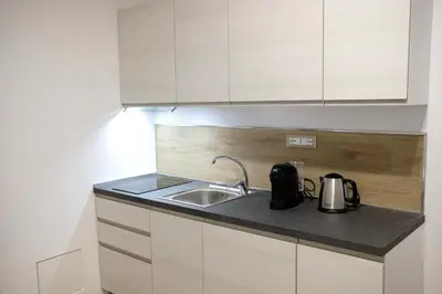 a kitchen with a sink and white cabinets at Belmonte Apartments in Palermo