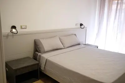 a bed in a bedroom with two lights on the wall at Belmonte Apartments in Palermo
