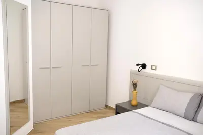 a bedroom with white cabinets and a bed at Belmonte Apartments in Palermo