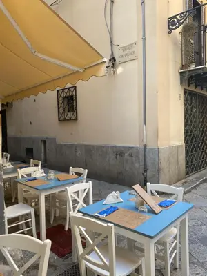 a row of tables and chairs in a restaurant at Tanto di Cappello Home in Palermo