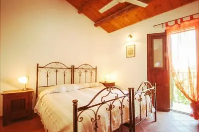 a bedroom with a bed in a room with a window at Il Casale il Sole e la Margherita in Campofelice di Roccella
