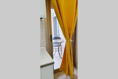 an open door to a room with a yellow curtain at LIBERTYHOUSE in Palermo