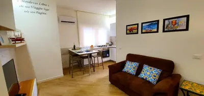 a living room with a couch and a kitchen at LIBERTYHOUSE in Palermo