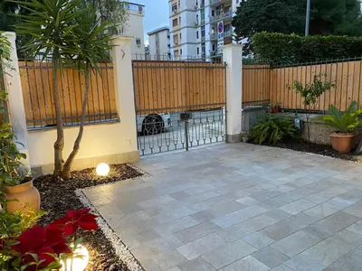 a patio with a fence and a tree in a yard at casa vacanze Sleep Art in Palermo