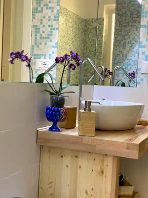 a bathroom with a sink and a vase with purple flowers at casa vacanze Sleep Art in Palermo