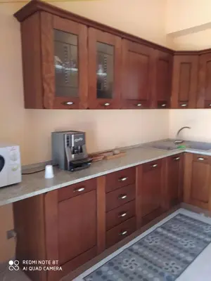 a kitchen with wooden cabinets and a microwave at Casa vacanze a Serra Scirocco in Trabia
