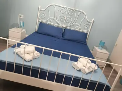 a bedroom with a white bed with blue sheets and towels at La terrazza sul vicolo in Palermo