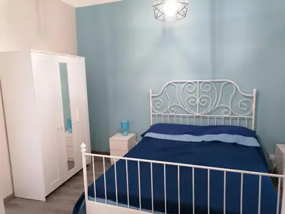 a bedroom with a bed and a blue wall at La terrazza sul vicolo in Palermo
