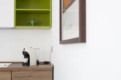 a kitchen with a green cabinet and a sewing machine at M'Place Apartments in Palermo