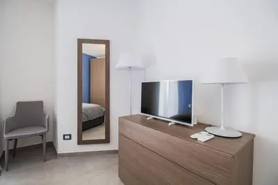 a room with a television on a dresser with a mirror at M'Place Apartments in Palermo