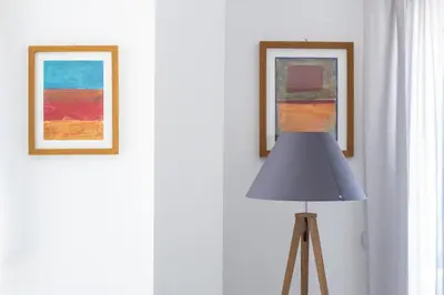 two framed paintings on a wall next to a lamp at M'Place Apartments in Palermo