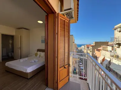 a bedroom with a bed on a balcony at Made In Sicilia -IN CENTRO, ARIA CONDIZIONATA e NO ZTL- CITY CENTRE, AIRCON and NO LTZ in Castellammare del Golfo