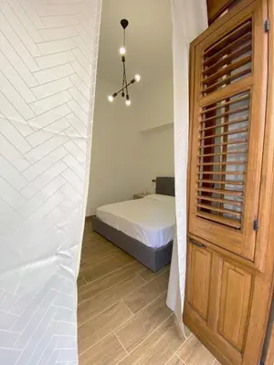 a bedroom with a bed and a wooden door at Medusa -IN CENTRO, ARIA CONDIZIONATA e NO ZTL -CITY CENTRE, AIRCON, NO LTZ in Castellammare del Golfo