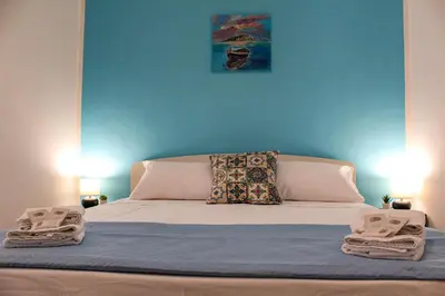 a bedroom with a bed with a blue wall at Casa Turà in Isola delle Femmine
