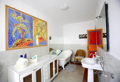 a bathroom with a sink and a toilet and a painting at CUBA'S ART HOUSE in Palermo