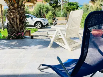 a pair of chairs sitting on a patio at VILLA OASI a 50 mt dalla spiaggia in Alcamo Marina
