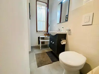 a bathroom with a white toilet and a sink at VILLA OASI a 50 mt dalla spiaggia in Alcamo Marina