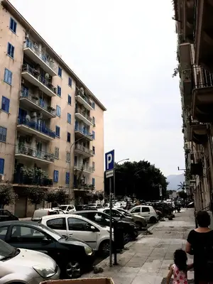a parking lot with cars parked in front of a building at Franco-Home in Palermo