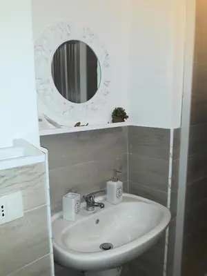 a bathroom with a sink and a mirror at Franco-Home in Palermo
