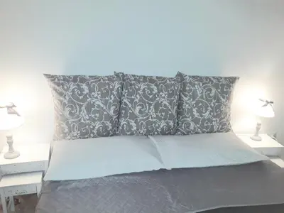 a bedroom with a bed with two lamps on tables at Franco-Home in Palermo