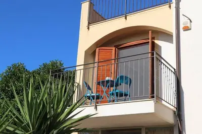 a house with a balcony with a blue chair on it at Villa Cavalluccio Marino con piscina idromassaggio in Carini