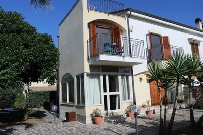 a white house with a balcony and a porch at Villa Cavalluccio Marino con piscina idromassaggio in Carini